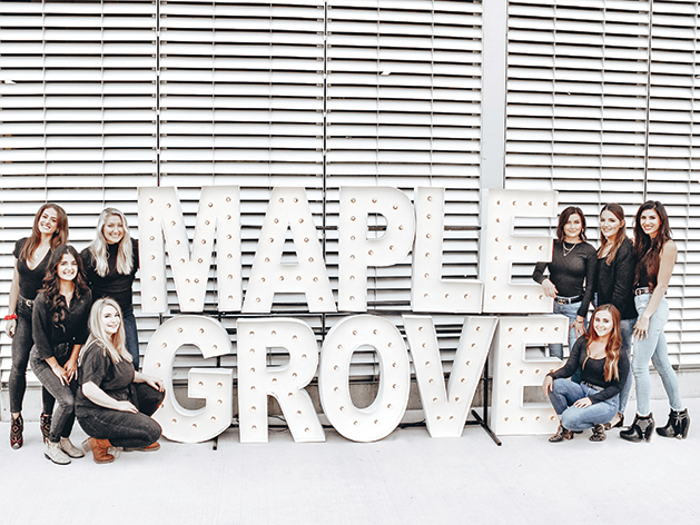 Women by Maple Grove sign