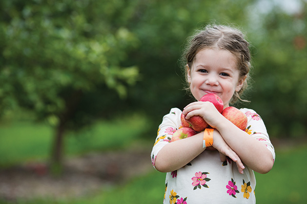 A girl holds apples at Apple Jack Orchards.