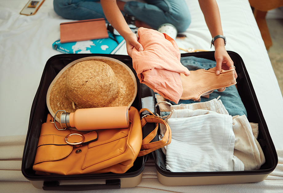 Hands, woman and suitcase on a bed for travel, adventure and summer vacation, packing and clothing. Hand, girl and luggage in a bedroom for travelling, abroad and break, relax and getaway preparation