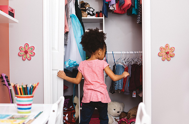 Little girl looking in her closet