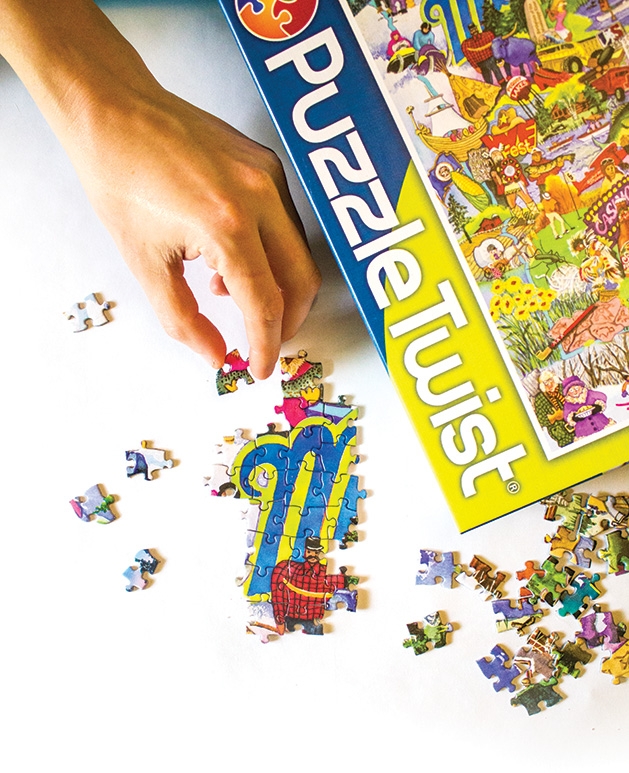 A person places pieces in a puzzle.