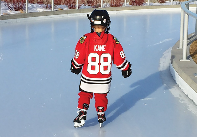 Little Boy Ice Skating in a Hockey Uniform
