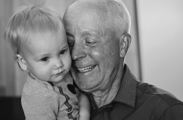 A grandfather holds his grandson in this Focus on Maple Grove winning photograph.