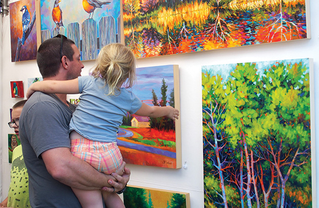 A man and his daughter look at some art at the Spirit of the St. Croix Art Festival.