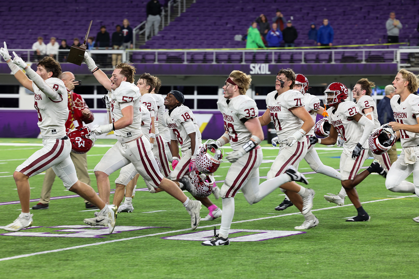 Crimson players celebrate their victory on the field of U.S. Bank Stadium.