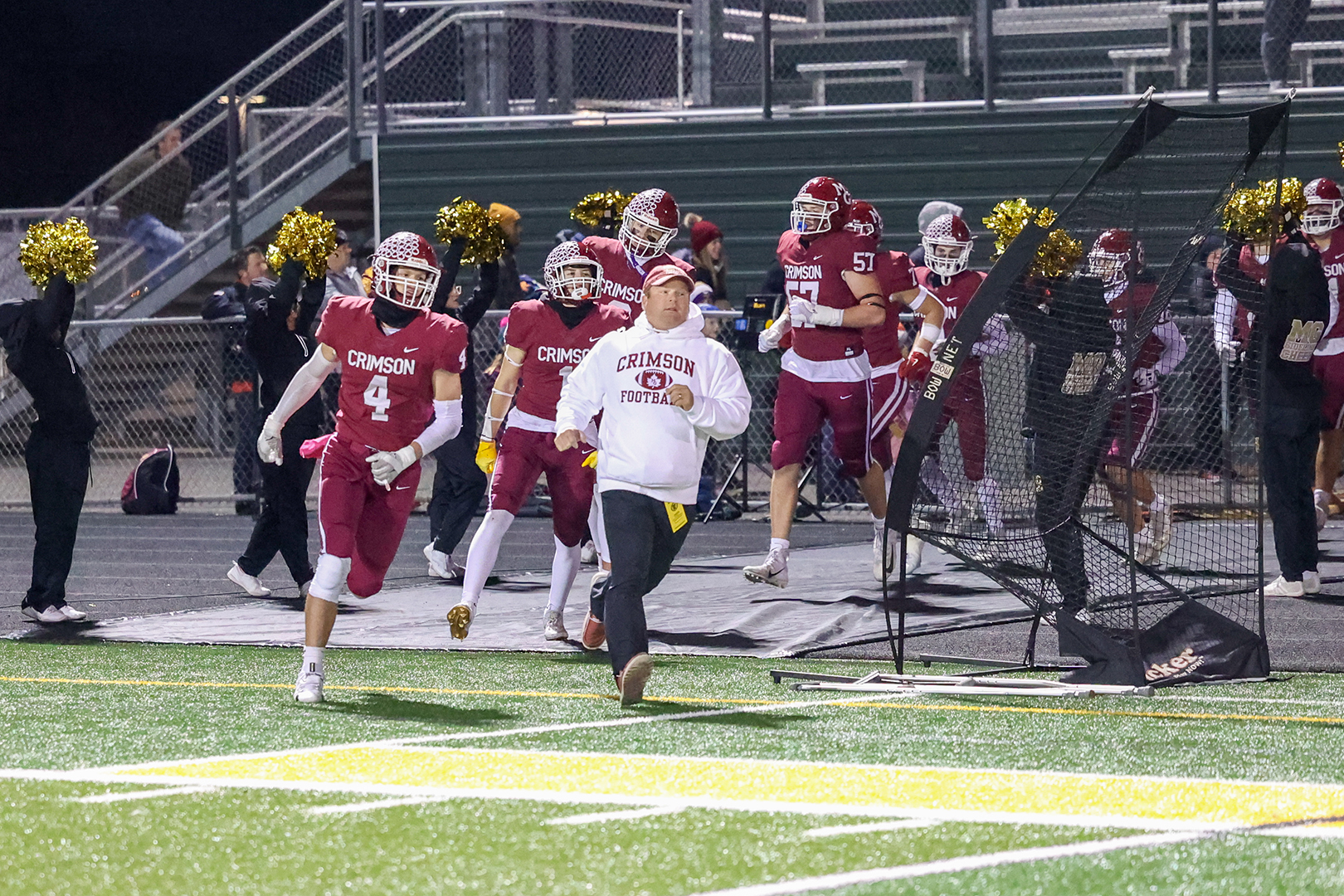 Head coach Adam Spurrell runs out alongside the Maple Grove Crimson.