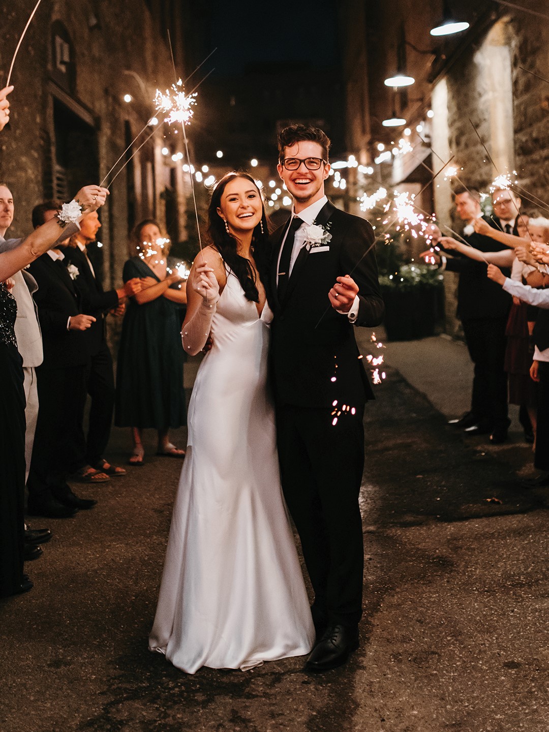 The groom’s suit, from Milbern Clothing Co., included a sophisticated black jacket with satin lapels and a textured floral tie. His look was complete with Calvin Klein Brodie Oxford shoes and a gift from his bride: custom cufflinks adorned with the faces of their pets. 