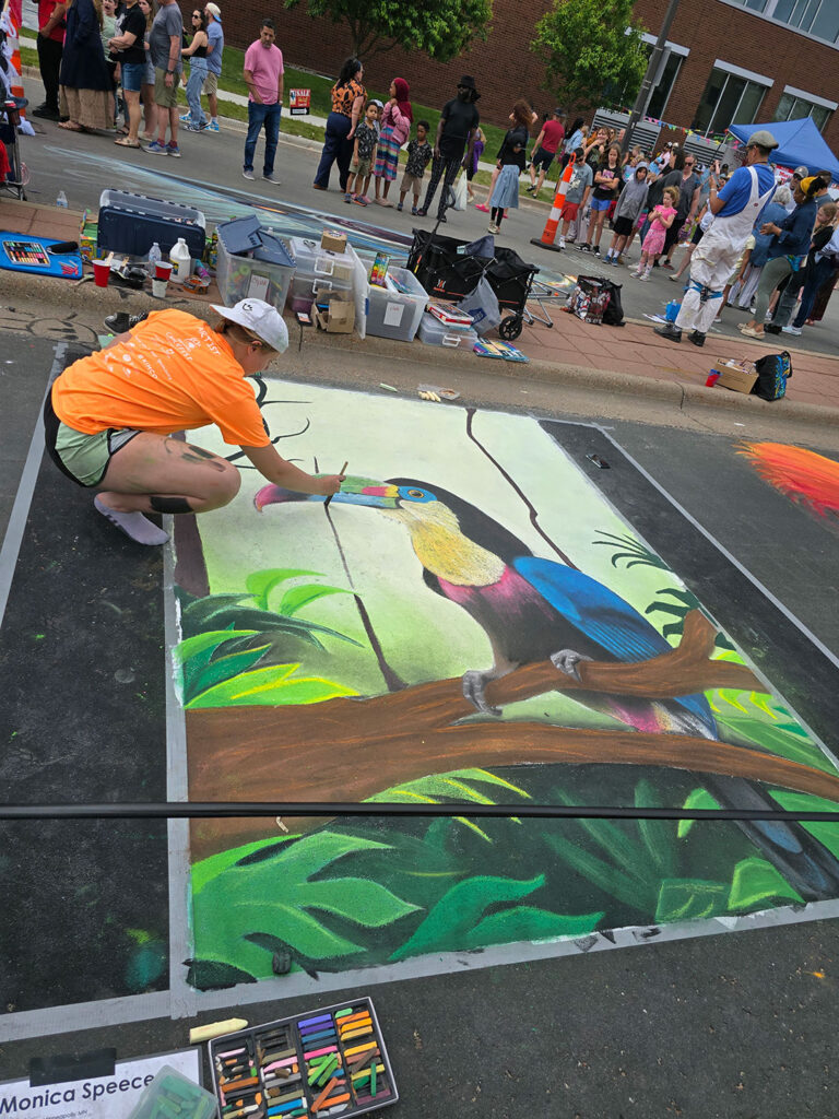 Chalkfest Maple Grove Artist Working on Toucan Mural