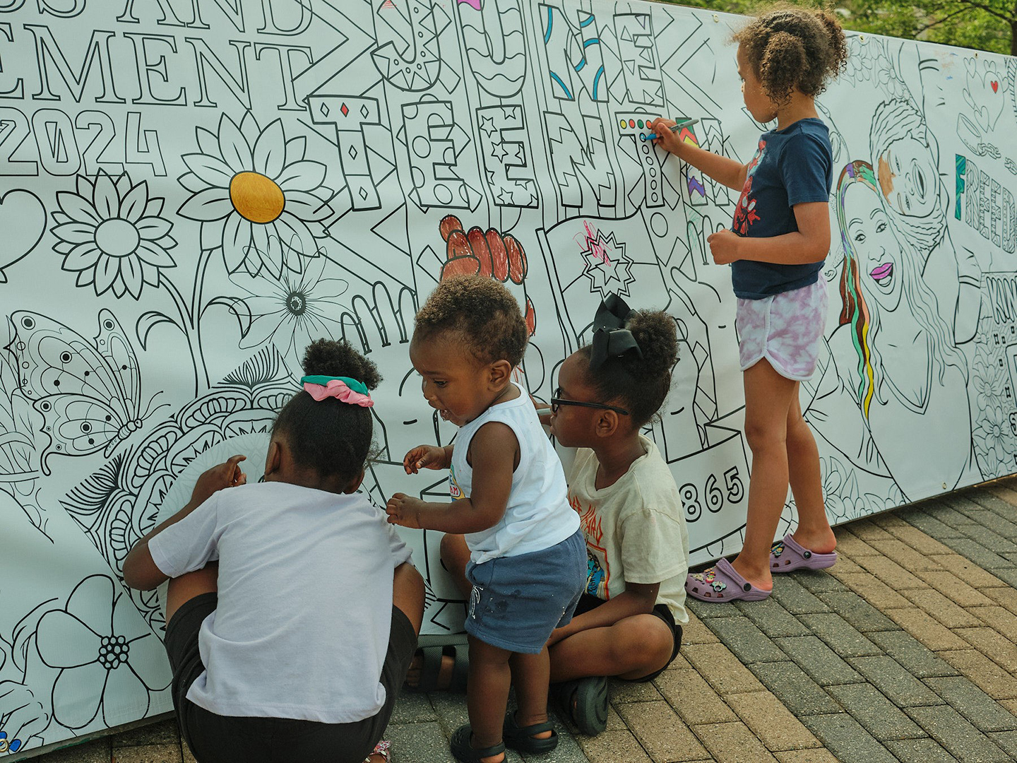 Kids coloring in a Juneteenth mural.