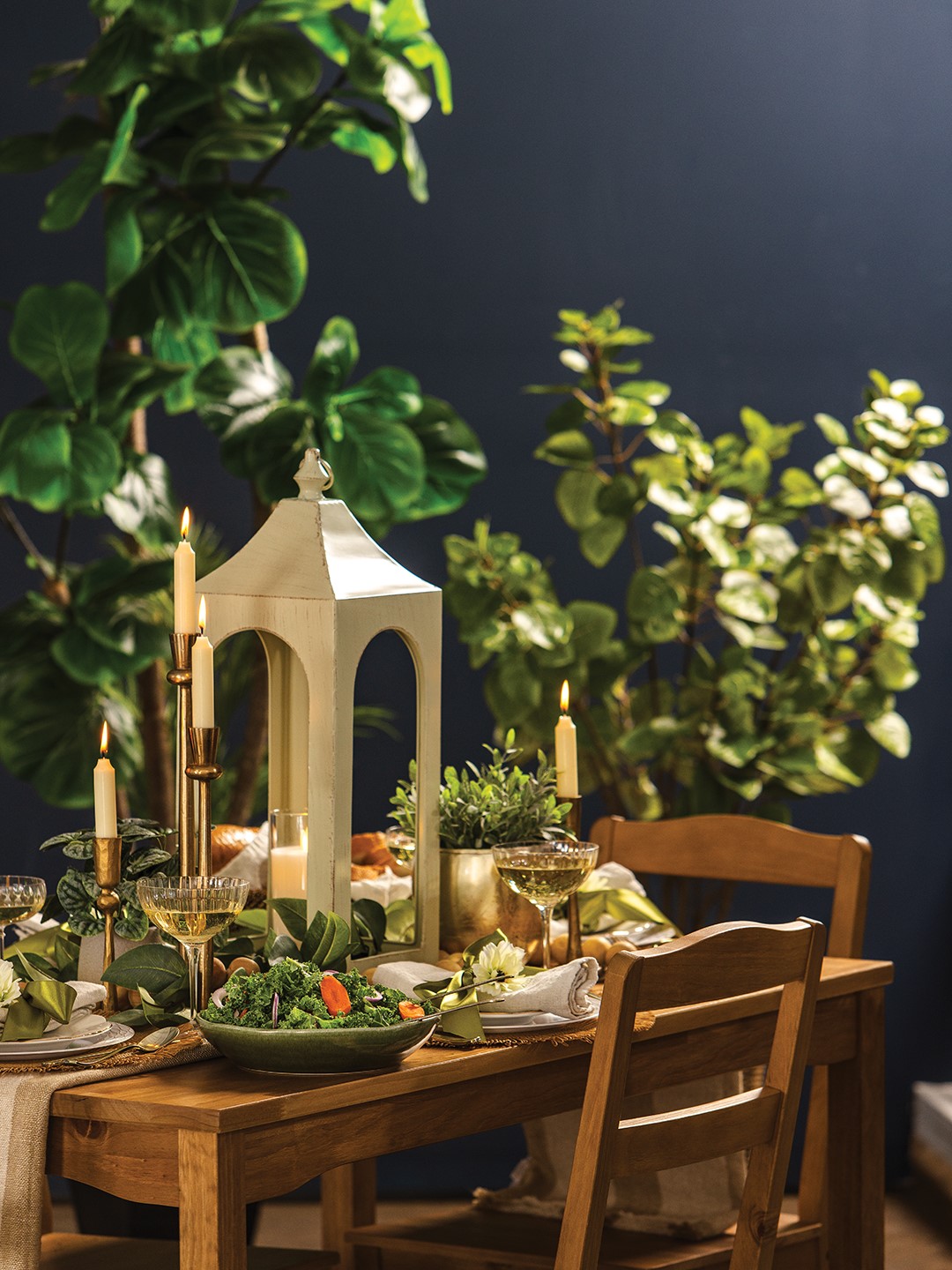 Mary Brueske loves to play with height using various candleholders including a metal arch lantern and a set of antique brass candle holders. Houseplants (real and faux) also add interest to the table.